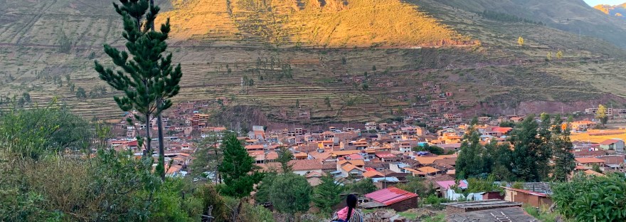 Paisaje andino con una persona caminando hacia una comunidad, imagen que ilustra cómo distintas culturas conciben el tiempo y el espacio.